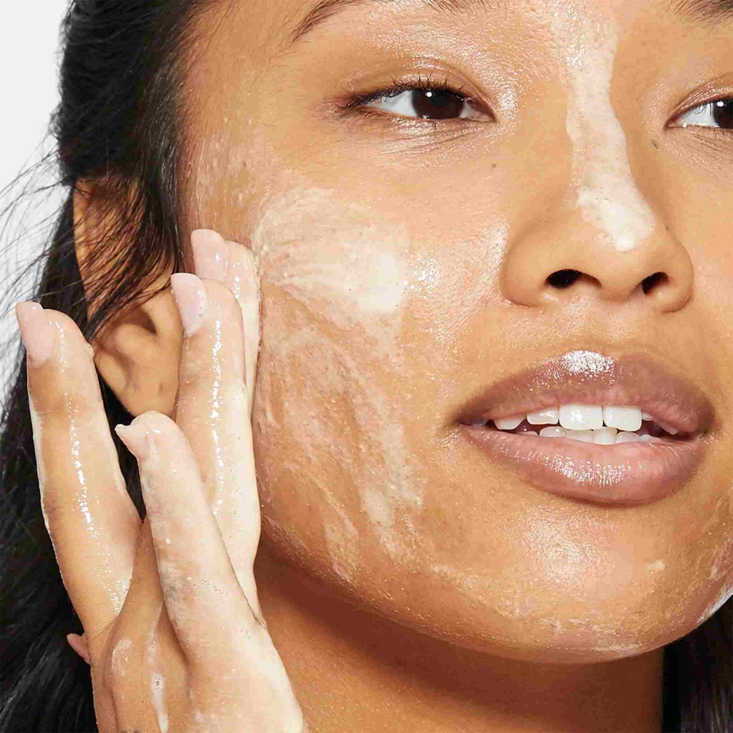 woman cleansing face with daily milkfoliant  